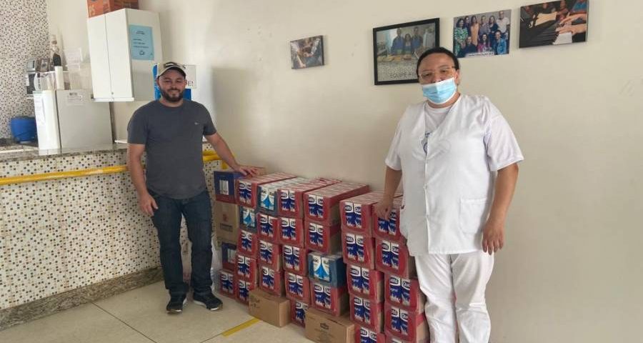 Humberto Bergamin, da cidade de Ibitiúra, entrega a doação de 450 litros de leite para a enfermeira Aline, do Cacon